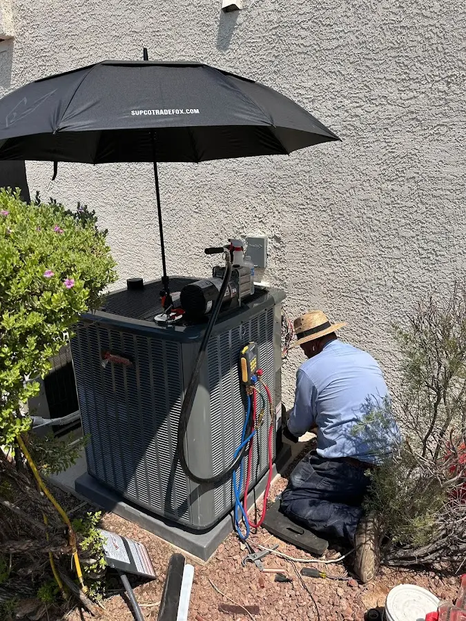 HVAC technician performing outdoor AC maintenance in Cimarron Hills
